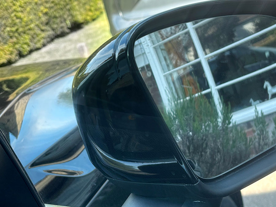 Close-up of a damaged wing mirror casing on a car needing repair or replacement
